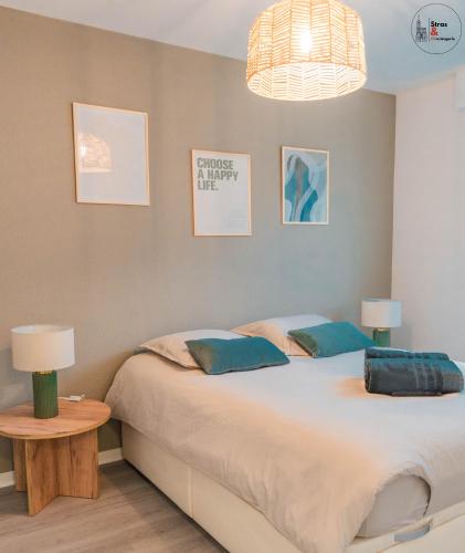 une chambre avec deux lits et une table avec une lampe dans l'établissement Chez la Clo' - joli 2 pièces, parking gratuit, accès direct tram 2 min à pied, à Strasbourg