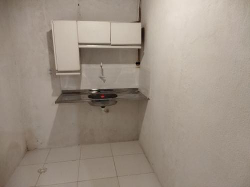 baño pequeño con lavabo y armarios blancos en Casa Prudente, en Olinda