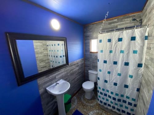 Baño azul con aseo y lavamanos en Departamentos altos de yelqui, en Puqueldón