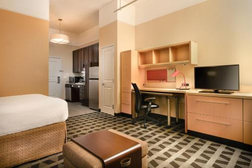 a hotel room with a bed and a desk with a computer at TownePlace Suites by Marriott Houston Westchase in Houston