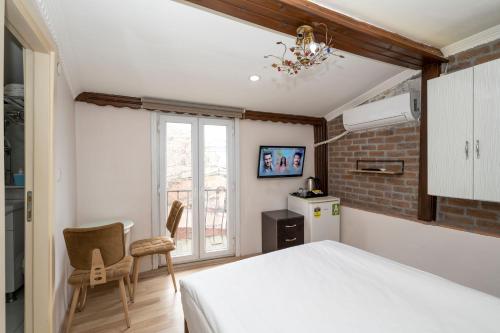 a bedroom with a bed and two chairs and a window at Taksim City Suite in Istanbul
