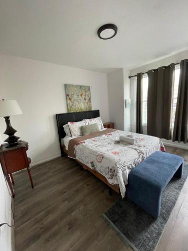 1 dormitorio con 1 cama y 1 reposapiés azul en Point Breeze South Philly (2 bedrooms), en Filadelfia