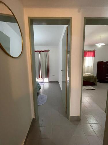 a hallway with a mirror and a bedroom at La casita de sol in Puerto Madryn
