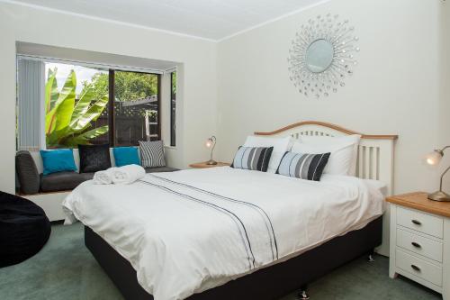 a bedroom with a large white bed and a window at Denby Crest in Whangarei