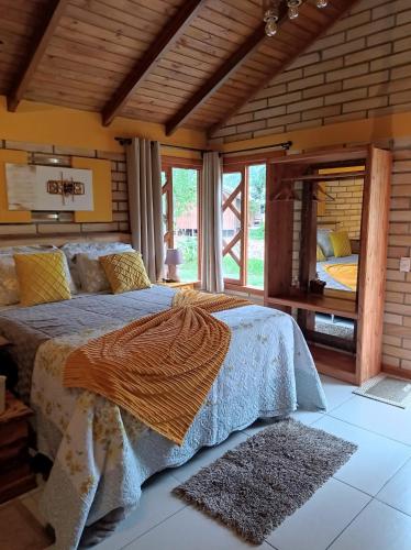 a bedroom with a bed and a large window at Chalé Girassol in Praia Grande