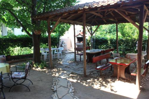 un patio con mesas y sillas bajo un pabellón de madera en Sunray Studios en Stavros