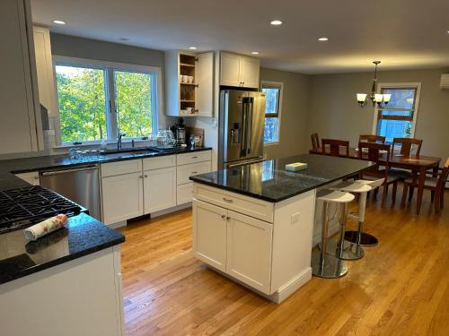 a kitchen with white cabinets and a kitchen island with a table at Room in Single Family House - Suburban Neighborhood in Boston in Boston