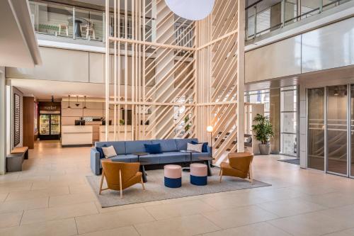 a lobby with a blue couch and chairs at Courtyard by Marriott Linz in Linz