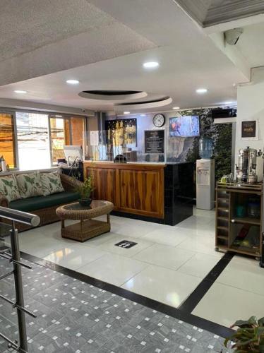 ein Wohnzimmer mit einem Sofa und einer Küche in der Unterkunft Hotel Emalú M&C in Quibdó