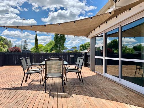 a patio with a table and chairs on a deck at M&K Home with central air condition, 4 bedrooms, by Chartwell Shopping Centre in Hamilton
