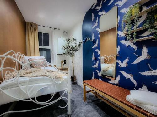 a bedroom with a bed and a blue wall with birds at Luxury, Interior-Designed, Spacious Home in Harrogate