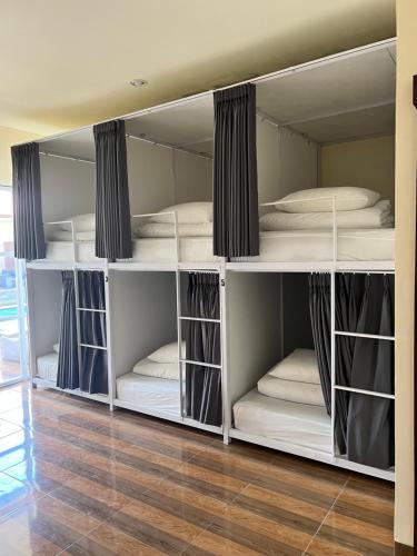 a room with white bunk beds in a room at LoTide Surf Camp Uluwatu in Uluwatu