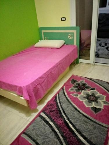 um quarto com uma cama rosa e um tapete em الاسكندرية جليم em Alexandria