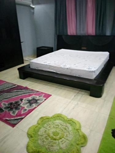 uma cama num quarto com dois tapetes no chão em الاسكندرية جليم em Alexandria