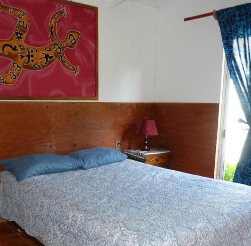 a bedroom with a bed and a window at Cabaña Kaiheke in Hanga Roa