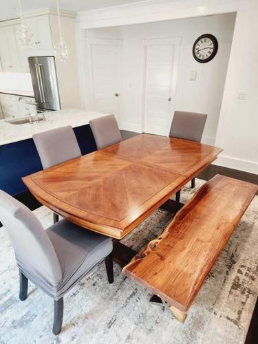 a wooden table and chairs in a kitchen with a clock at Charming and comfortable! in Medford
