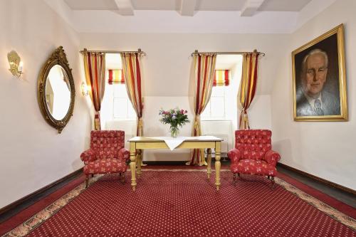 a living room with a table and two chairs at Hotel Graf von Mansfeld in Lutherstadt Eisleben