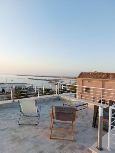 un patio con una mesa y una silla en el techo en A casa di nonna Maria, en Terrasini
