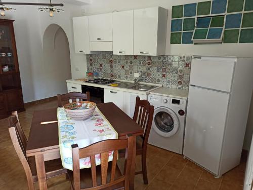 Una cocina con una mesa y sillas y un fregadero. en A casa di nonna Maria, en Terrasini