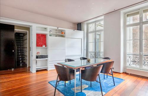 a kitchen with a dining room table and chairs at Chic Parisian Flat in Paris
