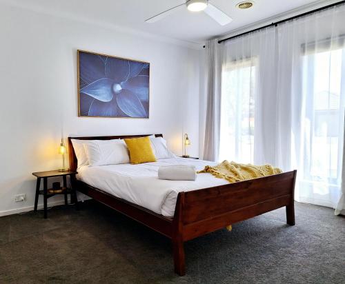 een slaapkamer met een groot bed en een groot raam bij Townhouse on Greybox in Kialla