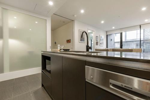 una cocina con encimera de acero inoxidable en City-edge Living in Trendy North Melbourne en Melbourne