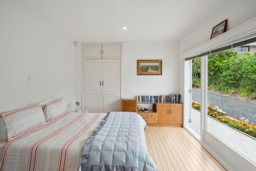 een slaapkamer met een bed en een groot raam bij Sun-drenched Bach - Leigh Holiday Home in Leigh