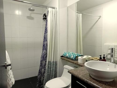 y baño con lavabo, aseo y ducha. en Downtown Quito - Balcony - Gym - Parking - 7thFLOOR, en Quito