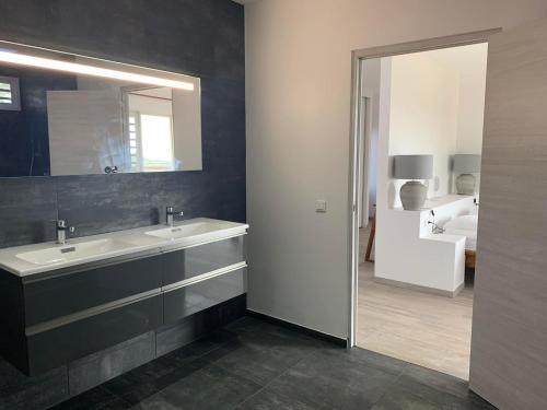 a bathroom with a sink and a mirror and a bed at Puunui Lodge in Vairao