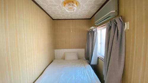 a small room with a bed and a window at 民宿奈良山月自助入住 请看邮件 in Nara