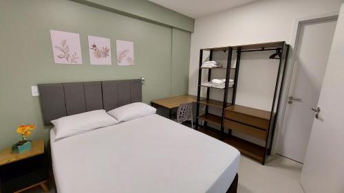 マセイオにあるConforto e tranquilidade, 2 quartos na Pajuçaraのベッドルーム(白いベッド1台、棚付)