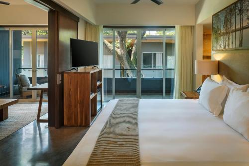 a bedroom with a large bed and a television at El Mangroove Papagayo, Autograph Collection in Papagayo, Guanacaste