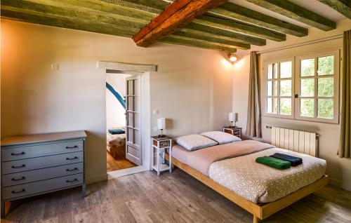 a bedroom with a large bed and a window at Pet Friendly Home In Fontaine-la-louvet With Outdoor Swimming Pool in Thiberville