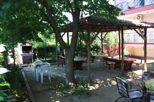 a pavilion with tables and chairs under a tree at Sunray Studios Stavros in Stavros