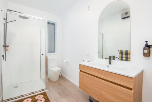 uma casa de banho com um lavatório e uma cabina de duche em vidro. em George Little em Dunedin