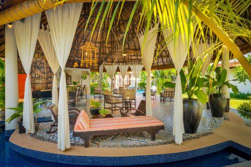 a bench in the middle of a room with plants at The Embassy Angkor Resort & Spa in Siem Reap