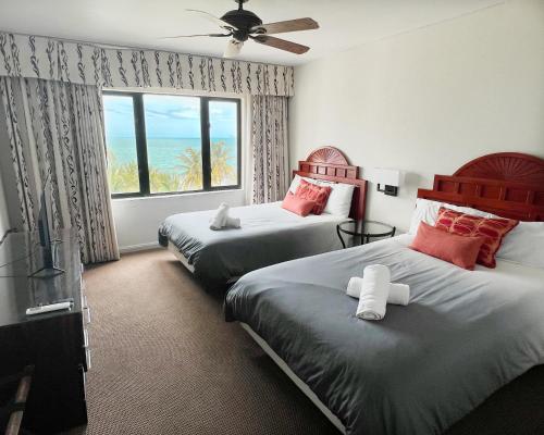 a bedroom with two beds and a large window at 1 bedroom beachfront Apartment at Rio Mar in Rio Grande