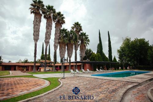 um resort com palmeiras e uma piscina em Quinta El Rosario em Lagos de Moreno