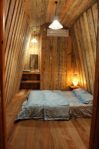 a bedroom with a bed in a wooden wall at Sultan Resort Syariah in Payakumbuh