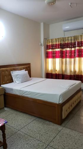 Taz Garden House في داكا: غرفة نوم بسرير كبير مع ستارة