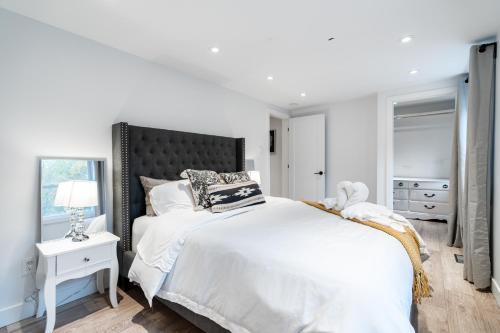 Un dormitorio blanco con una cama grande y una ventana en lacbrome Chalet lake+Terrasse+BBQ+Hot-tub, en Lac-Brome