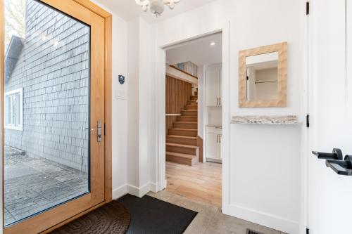 a hallway with a glass door leading to a staircase at lacbrome Chalet lake+Terrasse+BBQ+Hot-tub in Lac-Brome