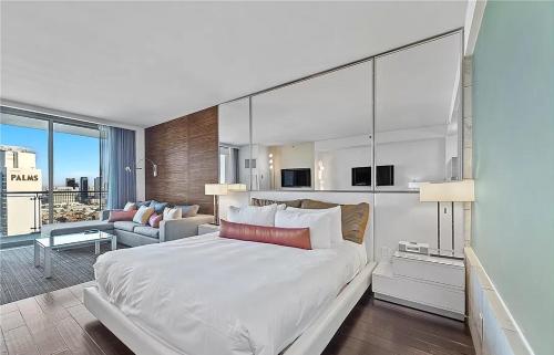 1 dormitorio con 1 cama blanca grande y sala de estar en Luxury Hotel Suite With Private Strip View Balcony en Las Vegas