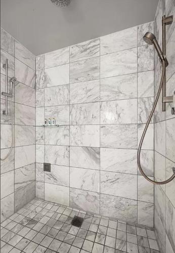 a bathroom with a shower with a marble wall at Luxury Hotel Suite With Private Strip View Balcony in Las Vegas