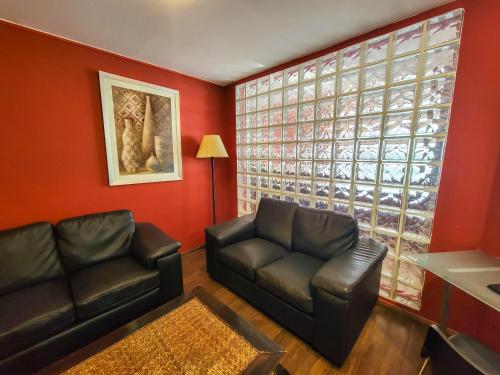 a living room with a couch and a glass wall at Hotel Genoves in Piriápolis