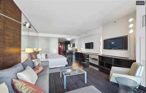 a living room with a couch and a tv at Luxury Hotel Suite With Private Strip View Balcony in Las Vegas