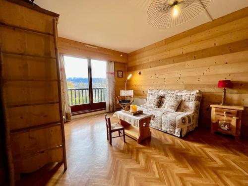 ein Schlafzimmer mit einem Bett und einem Tisch in einem Zimmer in der Unterkunft Les Xettes, bel appartement style chalet avec vue in Gérardmer