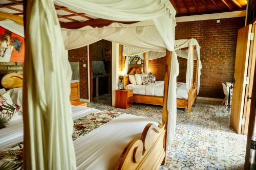 a bedroom with two beds in a room at Kanchana Cottages in Uluwatu
