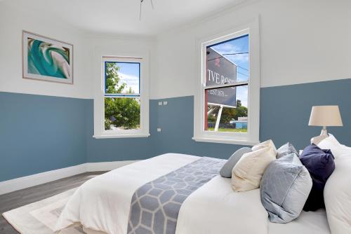 een slaapkamer met blauwe muren en een bed met kussens bij Native Rose Hotel in Sydney