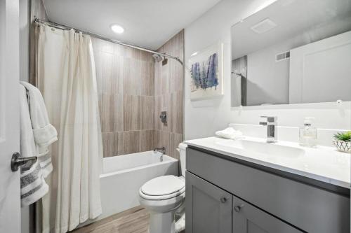 a bathroom with a sink and a toilet and a bath tub at Luxurious Condo with Rooftop and Parking near University City in Philadelphia